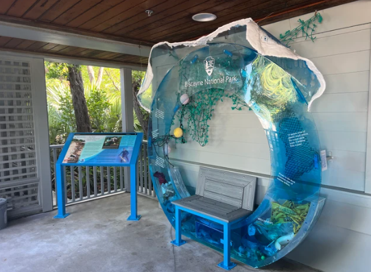 A large round interactive wave with marine debris and interpretive panel at the Biscayne National Park.